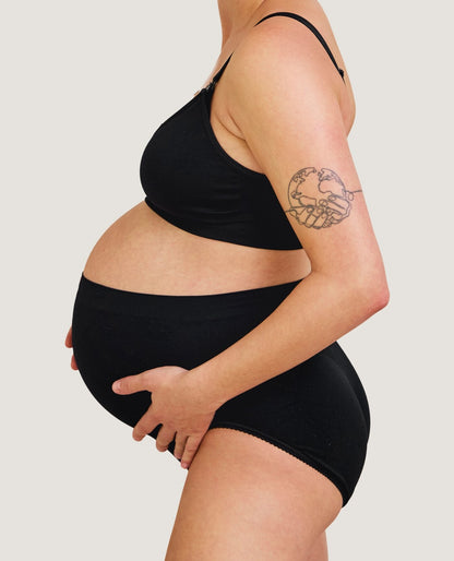 Carriwell sømløs graviditetstrusse i sort set fra siden på gravid mave